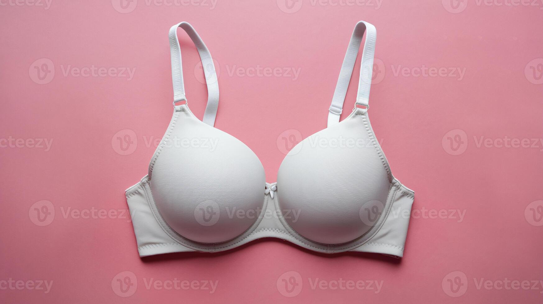 Elegant white bra on a pink background, showcasing a minimalist design for modern lingerie aesthetics. photo