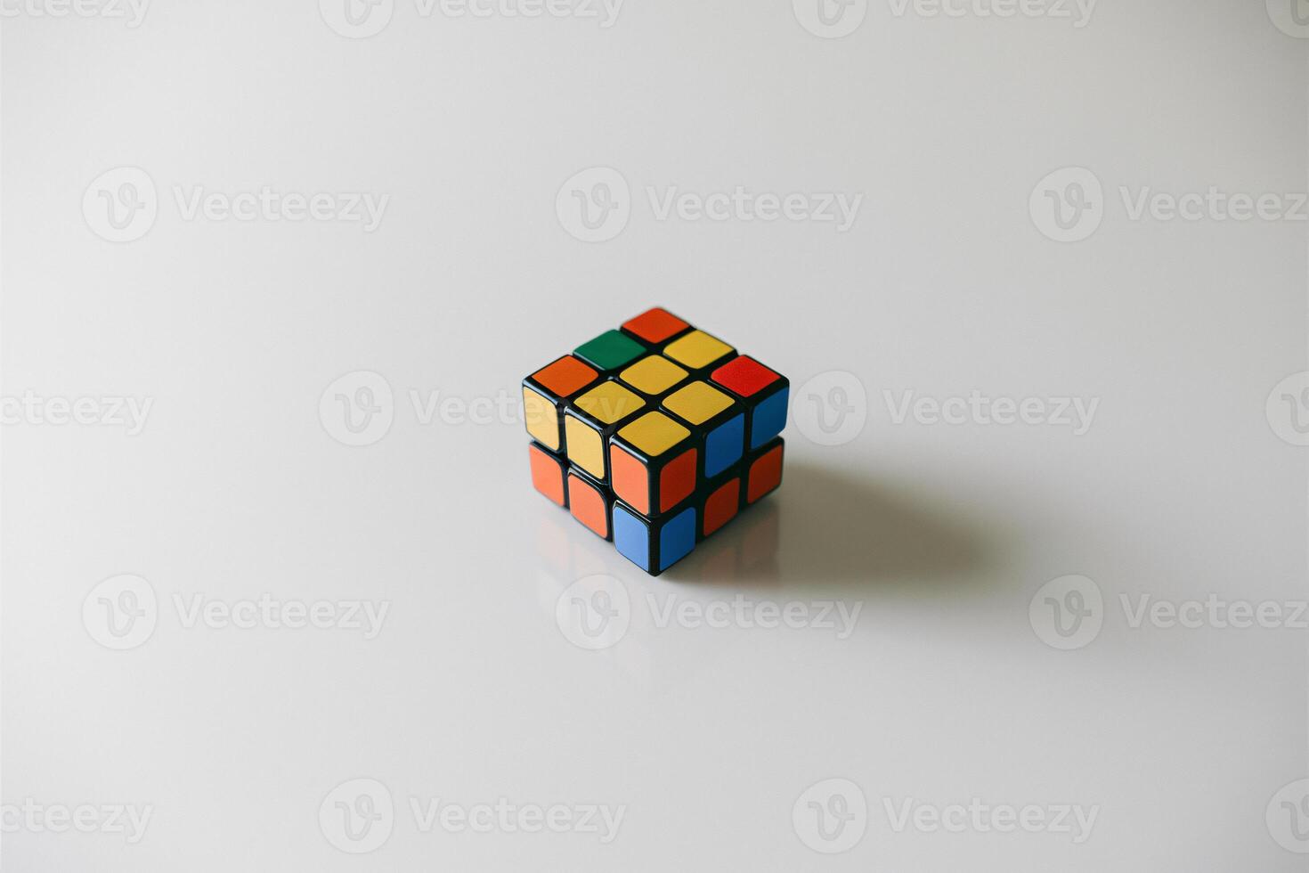 A colorful Rubik's Cube sits on a smooth white surface, inviting curiosity and challenge. photo