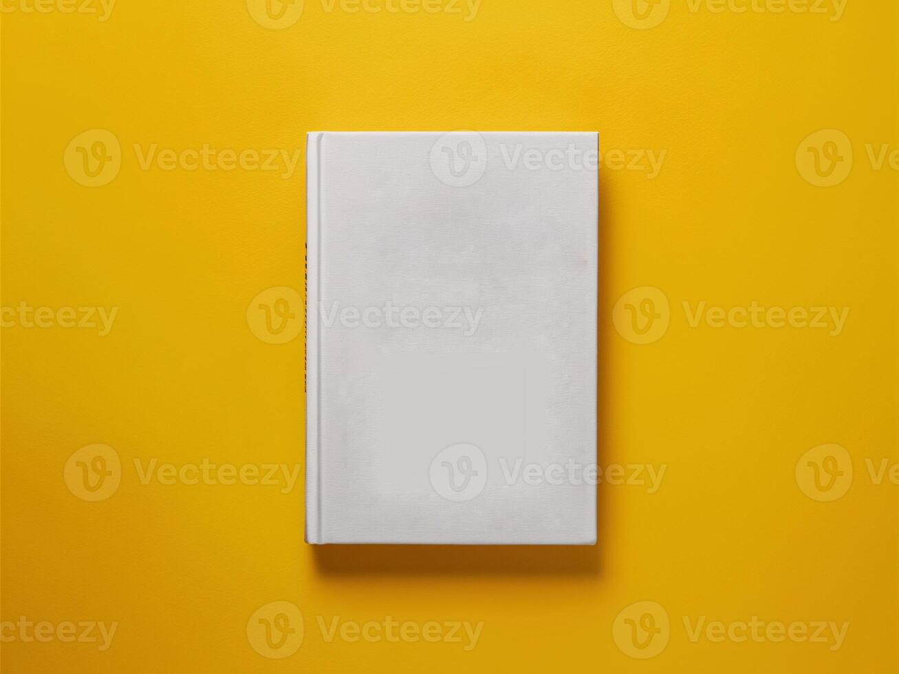 A blank white book placed on a vibrant yellow background, creating a minimalist aesthetic. photo
