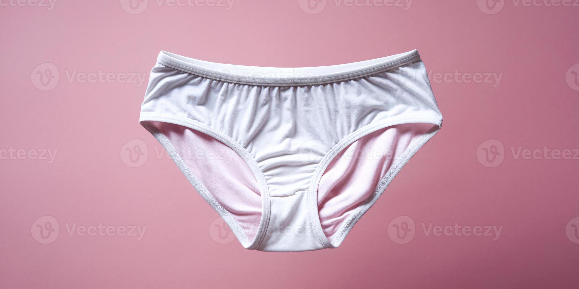 White women's underwear against a soft pink background, highlighting its simple and comfortable design. photo