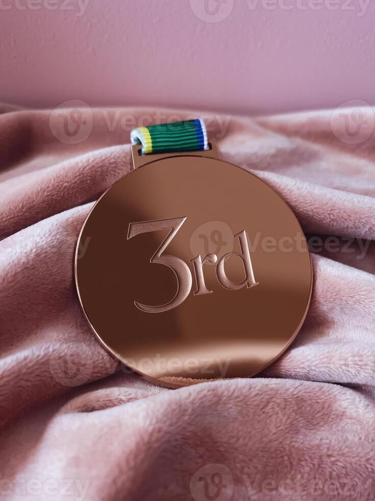 Bronze medal rests on soft fabric, symbolizing achievement and success in competition. photo