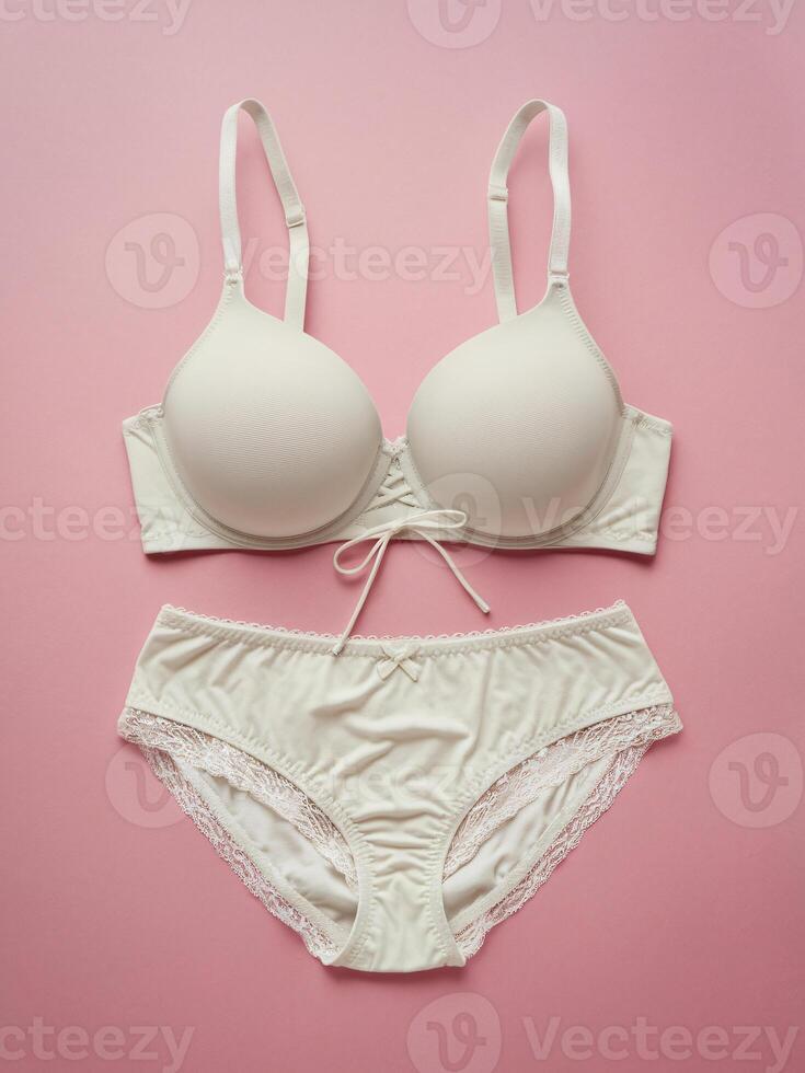 Elegant white lingerie set on pastel pink background, featuring a soft cup bra and matching panties. photo