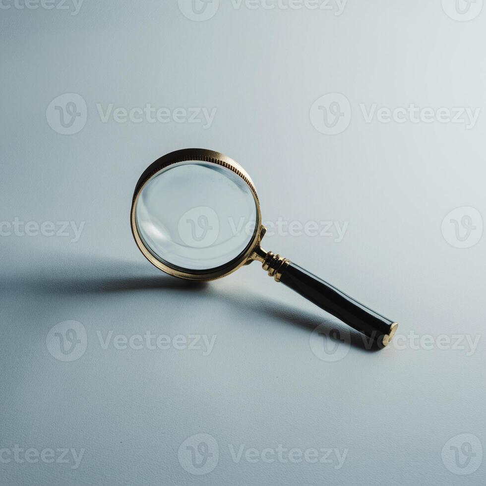 A vintage magnifying glass with a polished black handle, resting elegantly on a light surface. photo