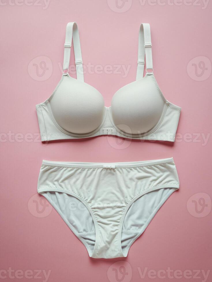 Elegant white lingerie set displayed on a soft pink background, emphasizing the delicate design. photo