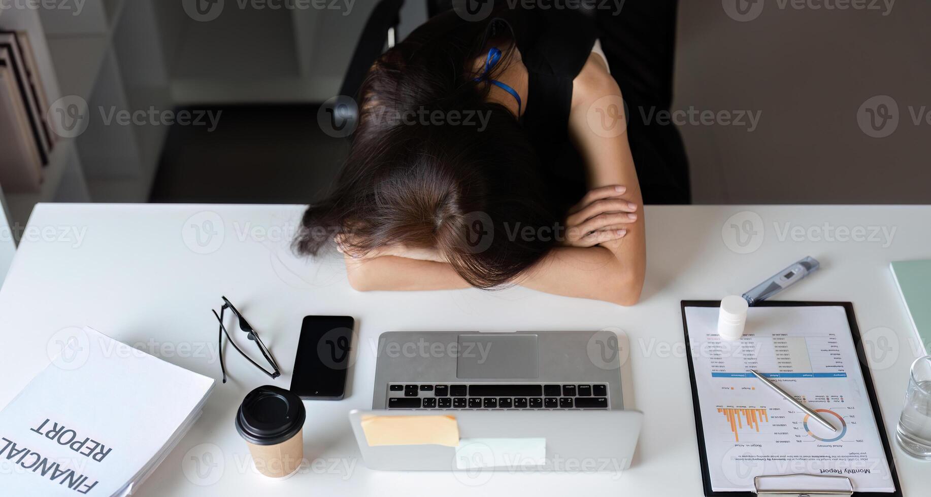 Exhausted Young Businesswoman Overwhelmed by Work Stress at Office Desk with Laptop and Documents photo