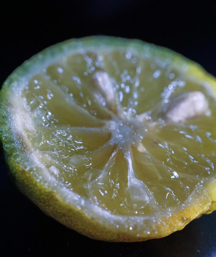 a close up of a lemon on a black surface photo