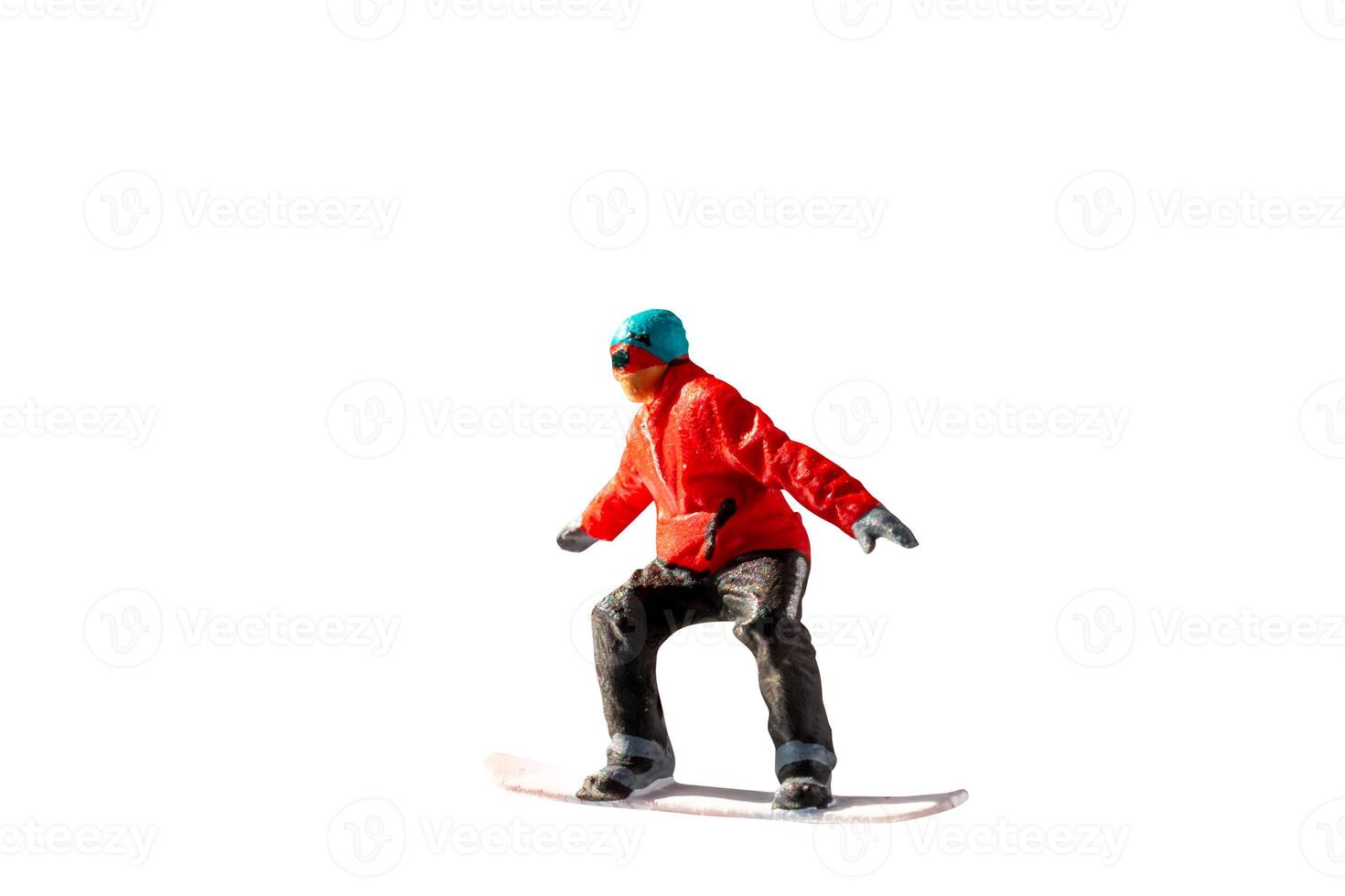 Miniature figurine depicting a snowboarder in mid-motion isolate on white background with clipping path photo