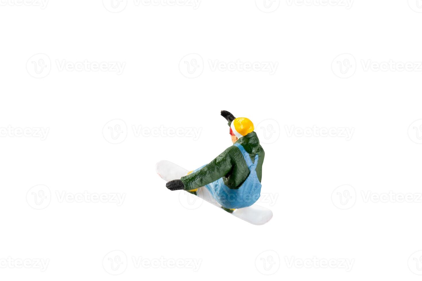 Miniature figurine depicting a snowboarder in mid-motion isolate on white background with clipping path photo
