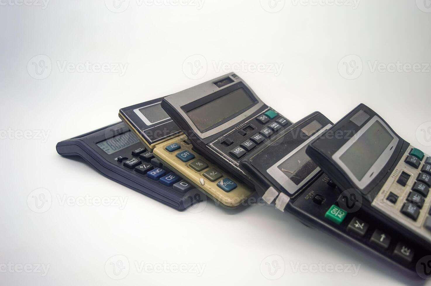 A pile of old calculators symbolizes inflation, representing outdated financial tools and the increasing cost of living photo