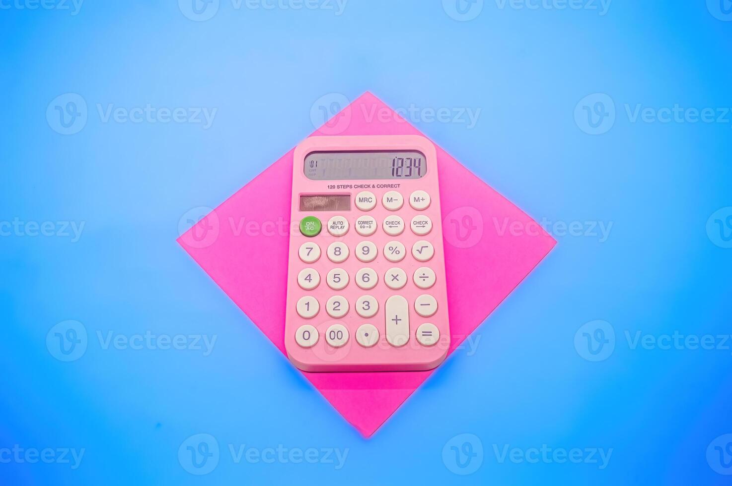 A pink calculator displaying the number 1234 is placed on a pink square paper against a blue background. The vibrant colors make it visually appealing and eye catching photo