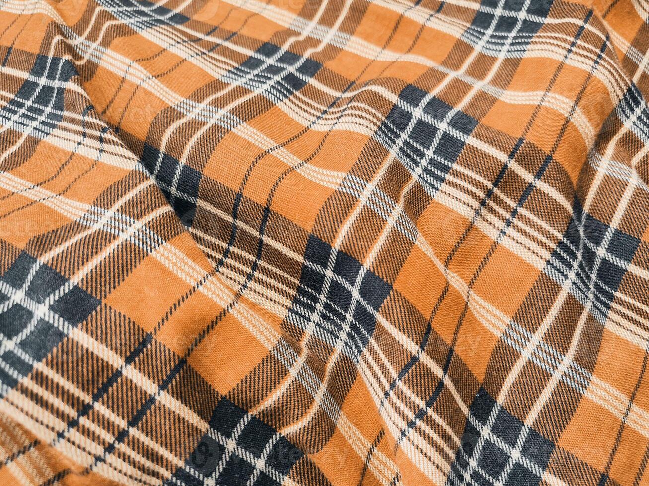 The pattern and background of the fabric has a orange checkered motif photo