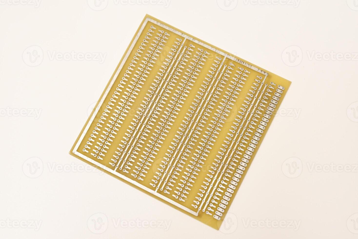 A yellow breadboard for electronics on a white background. Printed circuit boards for mounting radio elements. photo