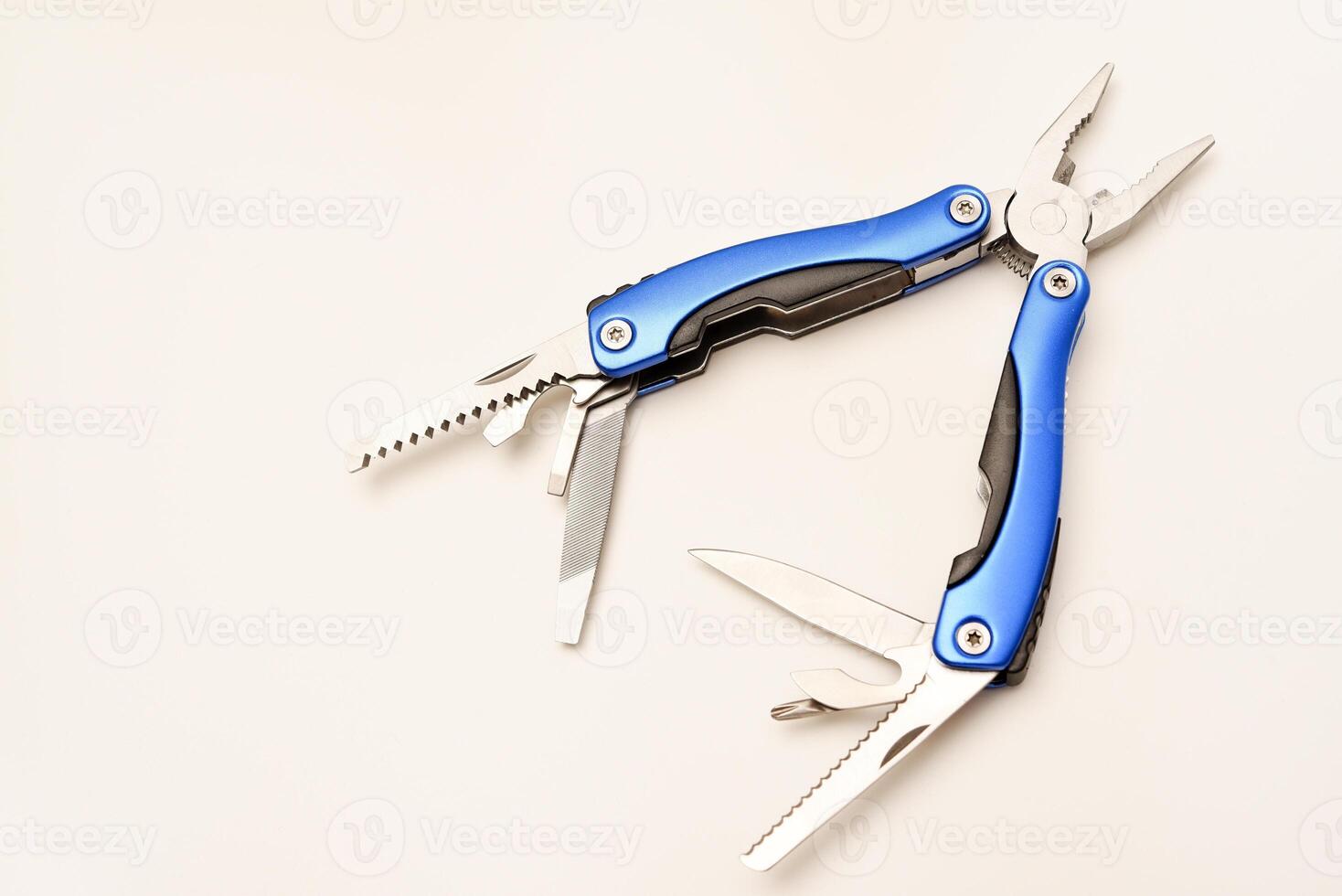 Multitool on a white background. Pocket multi-tool. Saw, knife and pliers. photo