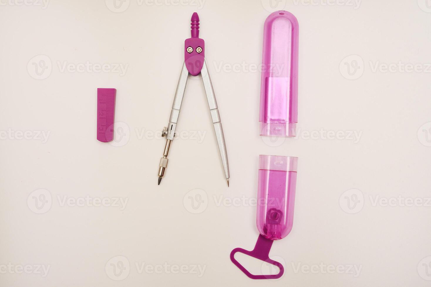 Pink compasses on a white background. A drawing tool. photo
