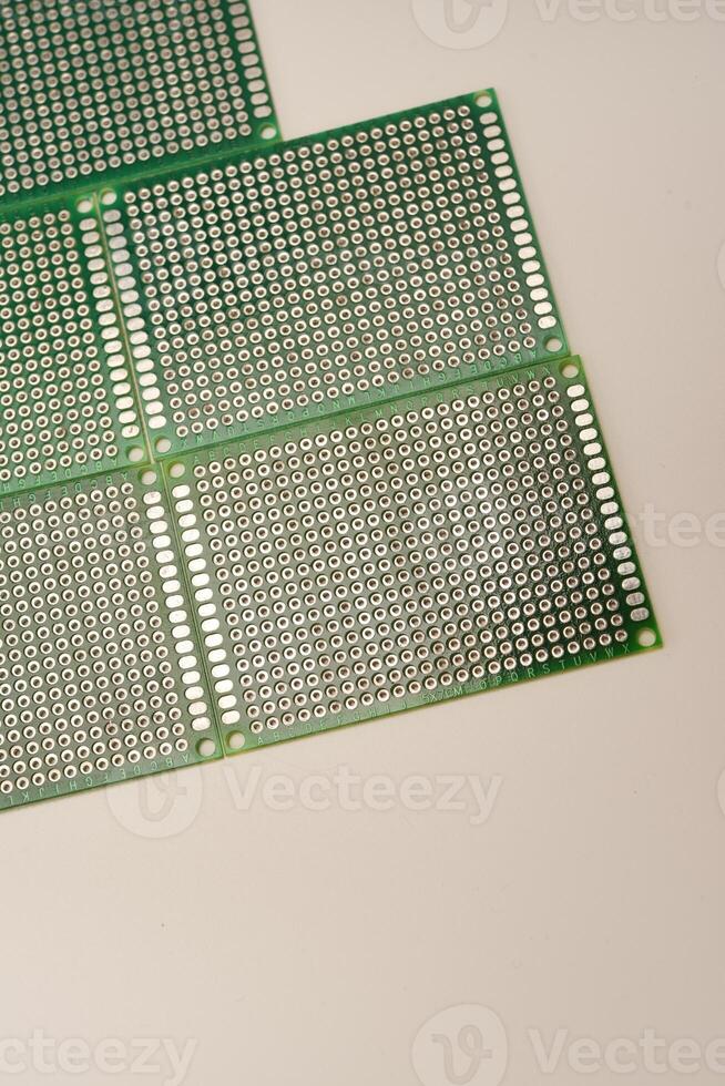 A green breadboard for electronics on a white background. Printed circuit boards for mounting radio elements. photo