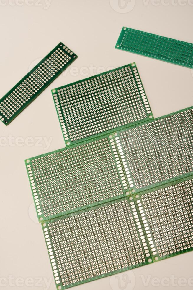 A green breadboard for electronics on a white background. Printed circuit boards for mounting radio elements. photo