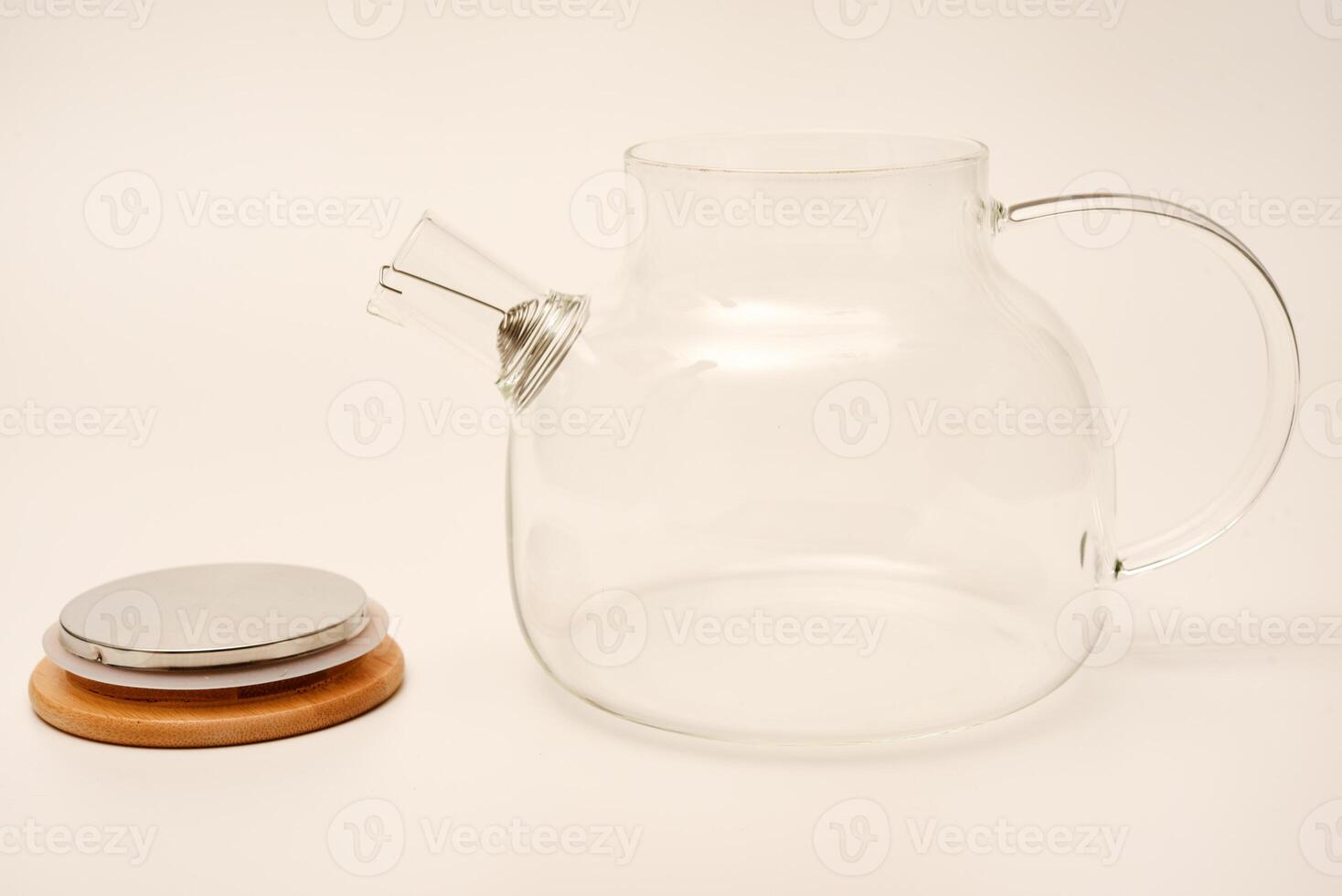 Glass teapot with wooden lid on a white background. photo