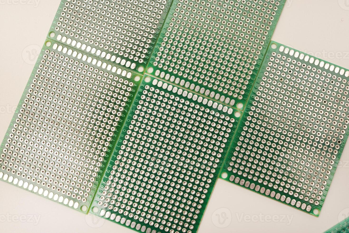 A green breadboard for electronics on a white background. Printed circuit boards for mounting radio elements. photo