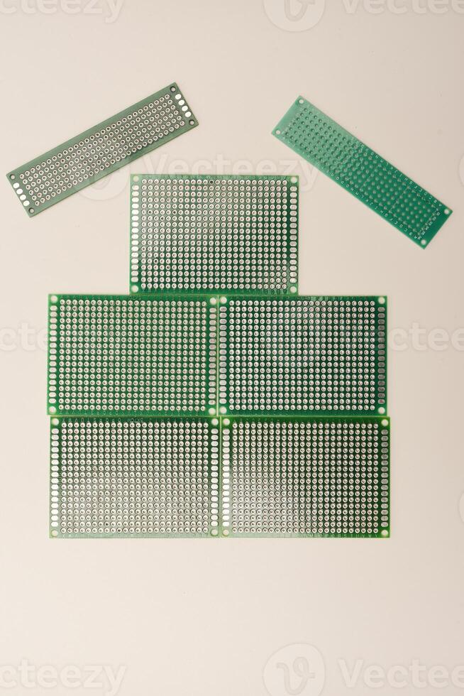 A green breadboard for electronics on a white background. Printed circuit boards for mounting radio elements. photo