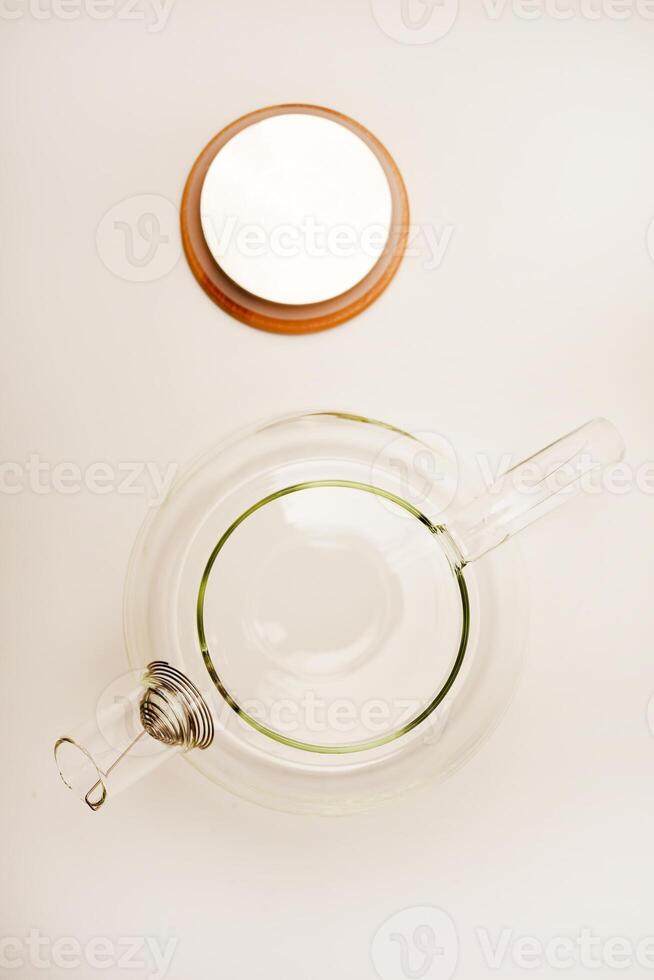 Glass teapot with wooden lid on a white background. photo