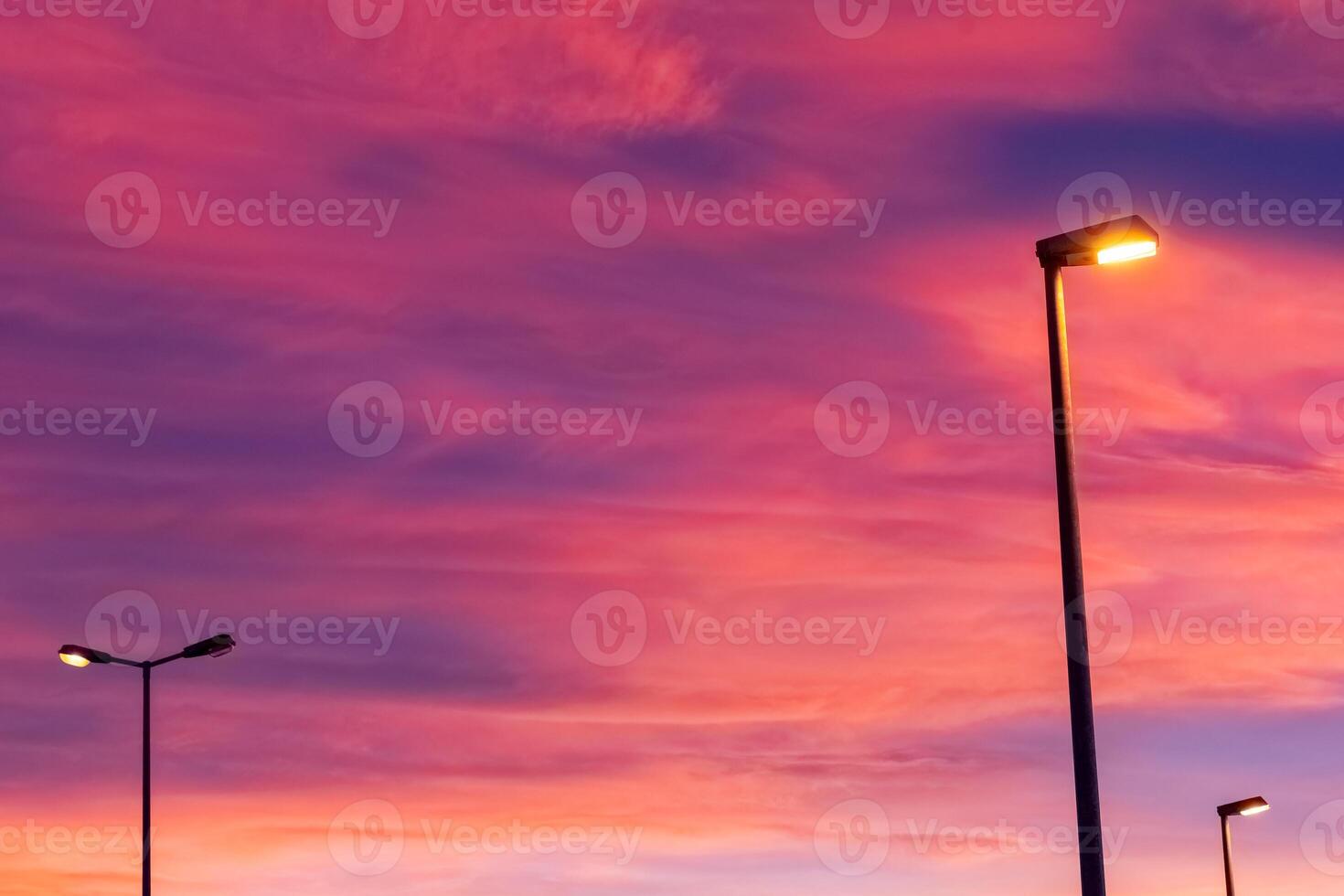 Vibrant sunset colors illuminate street lamps in evening sky setting photo
