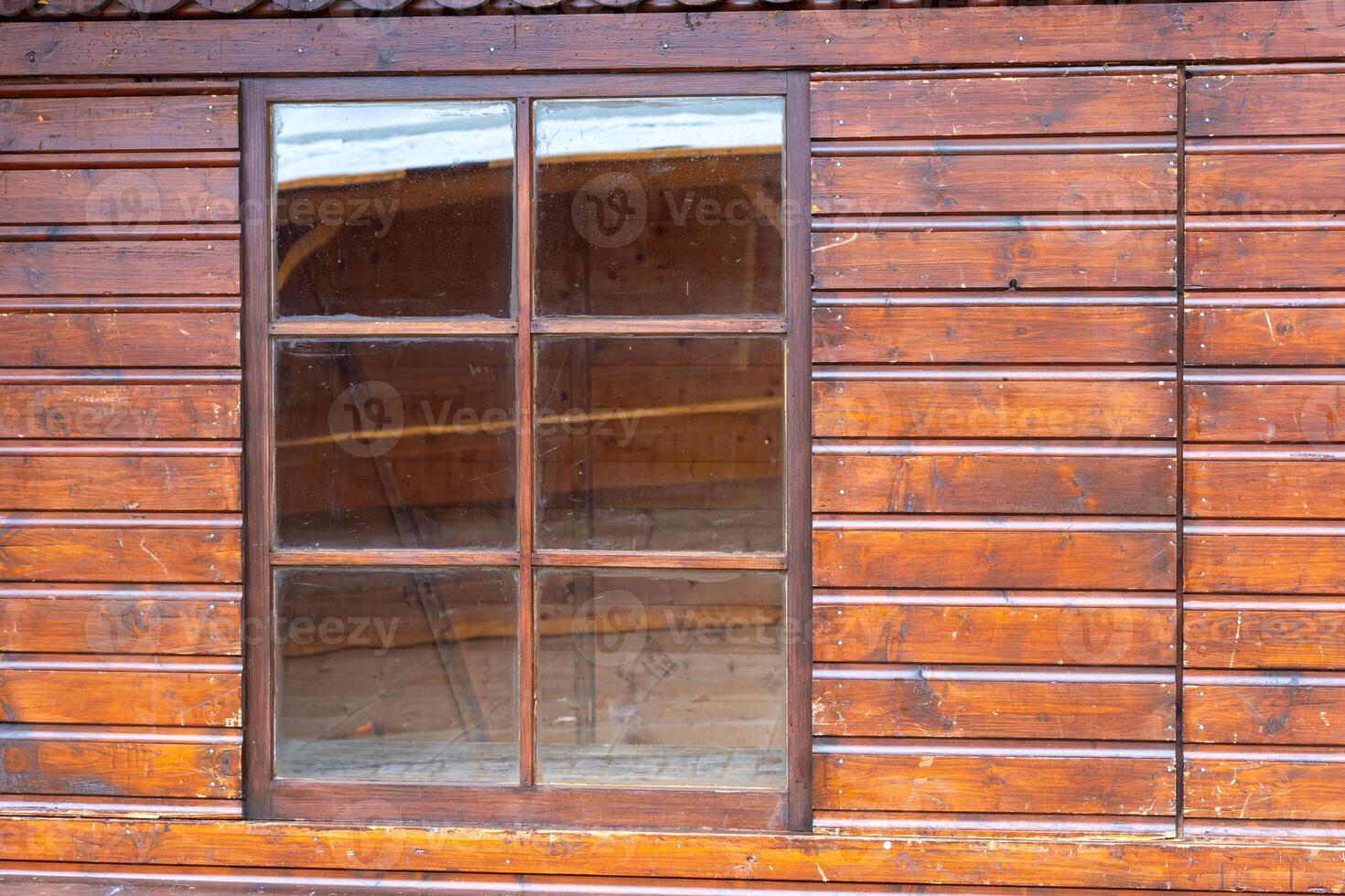 Classic wooden cabin window showcasing natural wooden textures and rustic charm in afternoon light photo