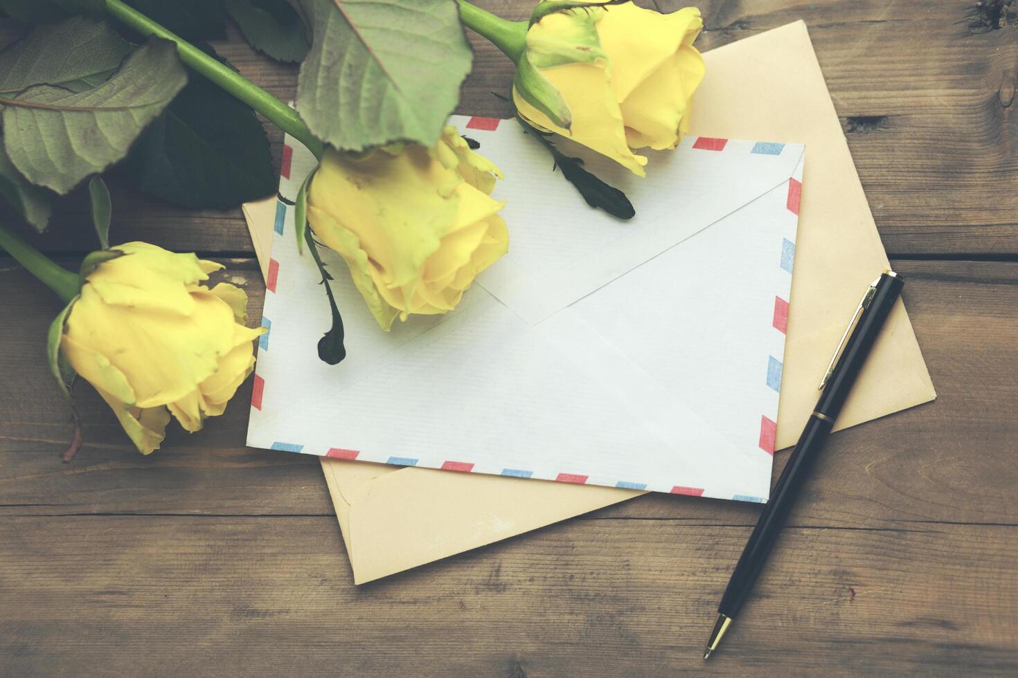 yellow rose with letters on table photo