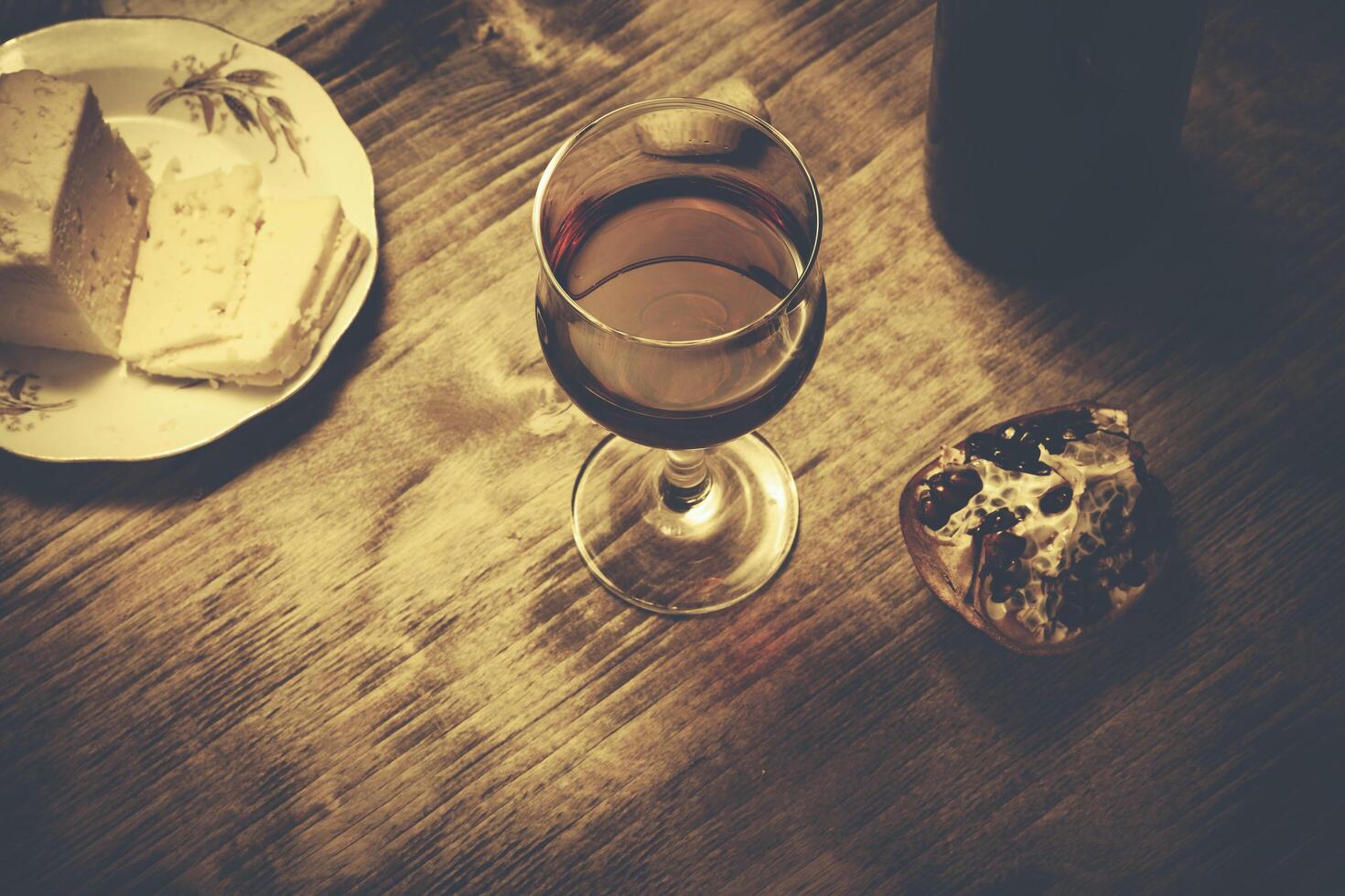 wine glass with cheese and pomegranate photo