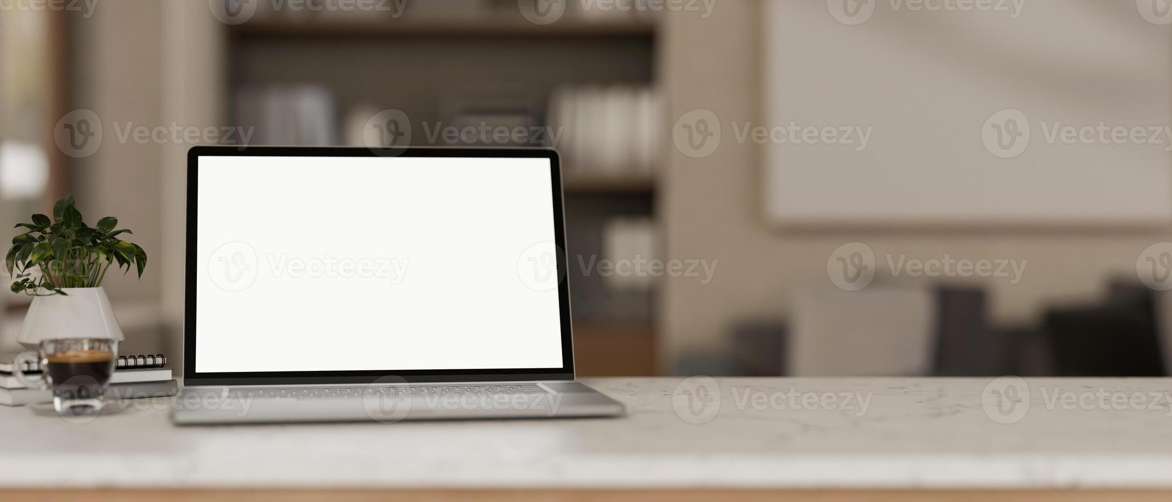 A laptop with a white screen mockup placed on a desk, with a blurred background of a cozy room. photo
