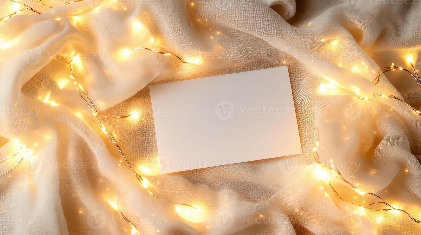 Blank card mockup lying on soft fabric, surrounded by warm fairy lights, highlighting festive atmosphere for personal messages or celebratory communication photo