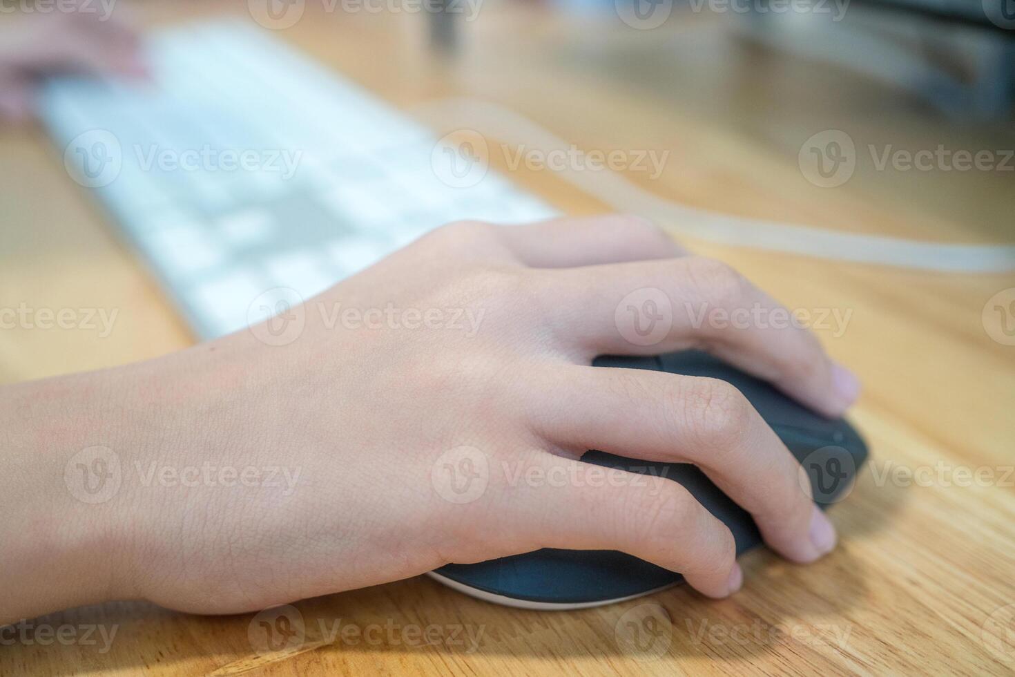 Girl's hand with computer mouse and keyboard photo