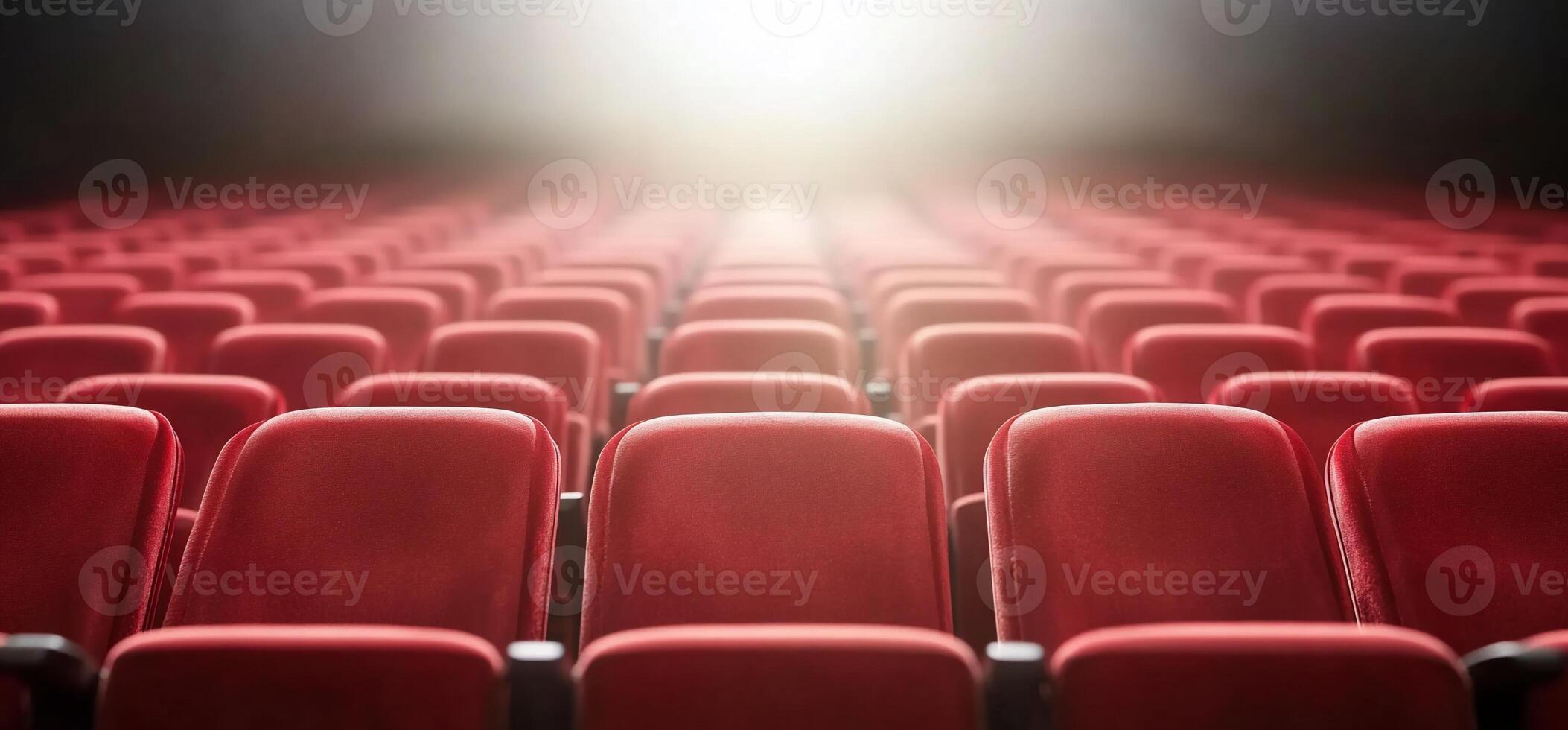 Rows of red theater seats illuminated by bright light. photo