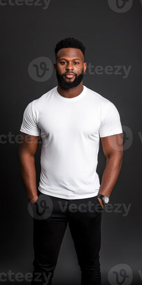 Man in white t-shirt poses confidently against a dark backdrop photo