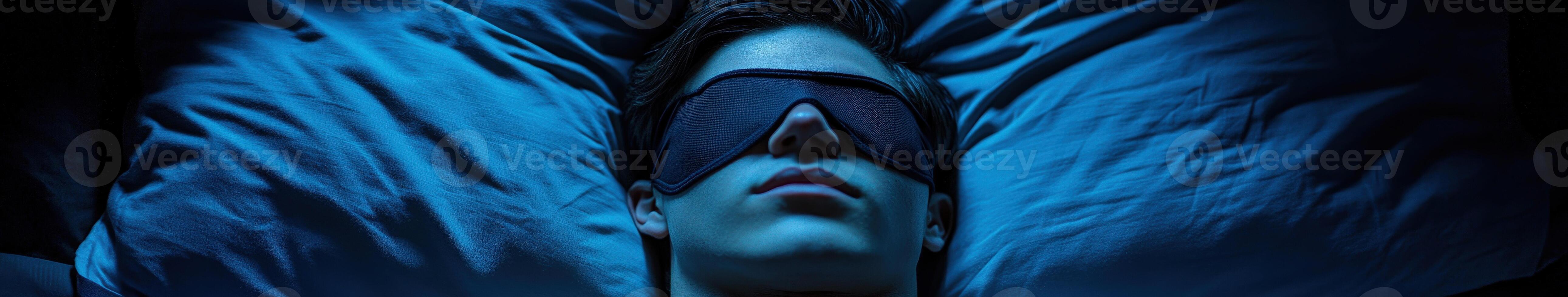 Young person resting peacefully in a darkened room with sleep mask photo