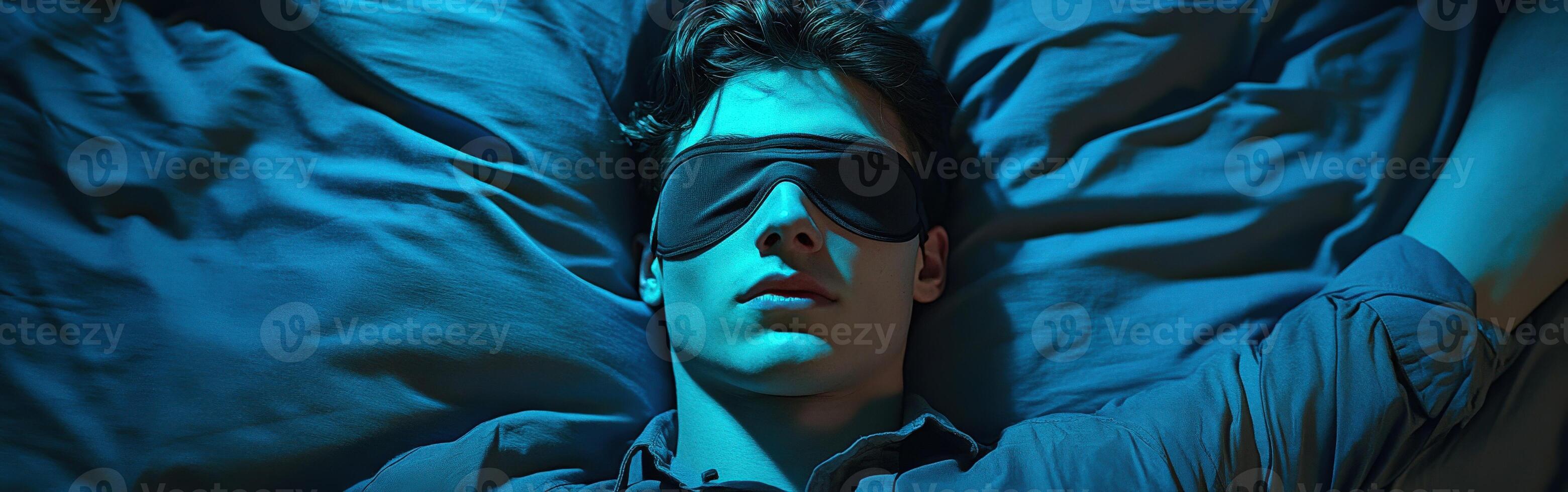 Young man resting peacefully wearing a sleep mask in a dimly lit room photo