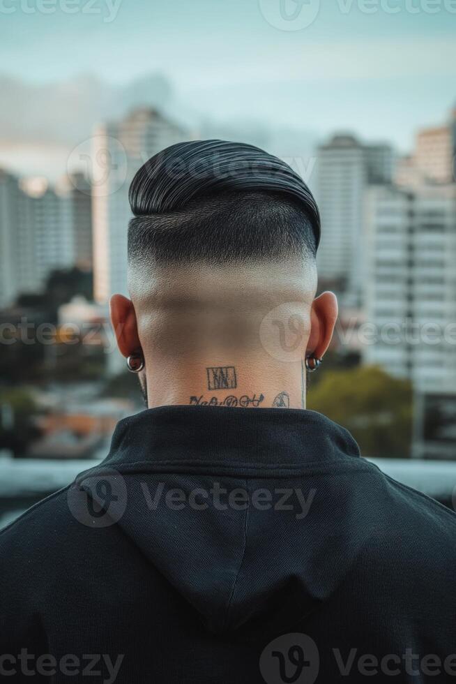 Stylish haircut on a young man with city skyline backdrop during twilight photo