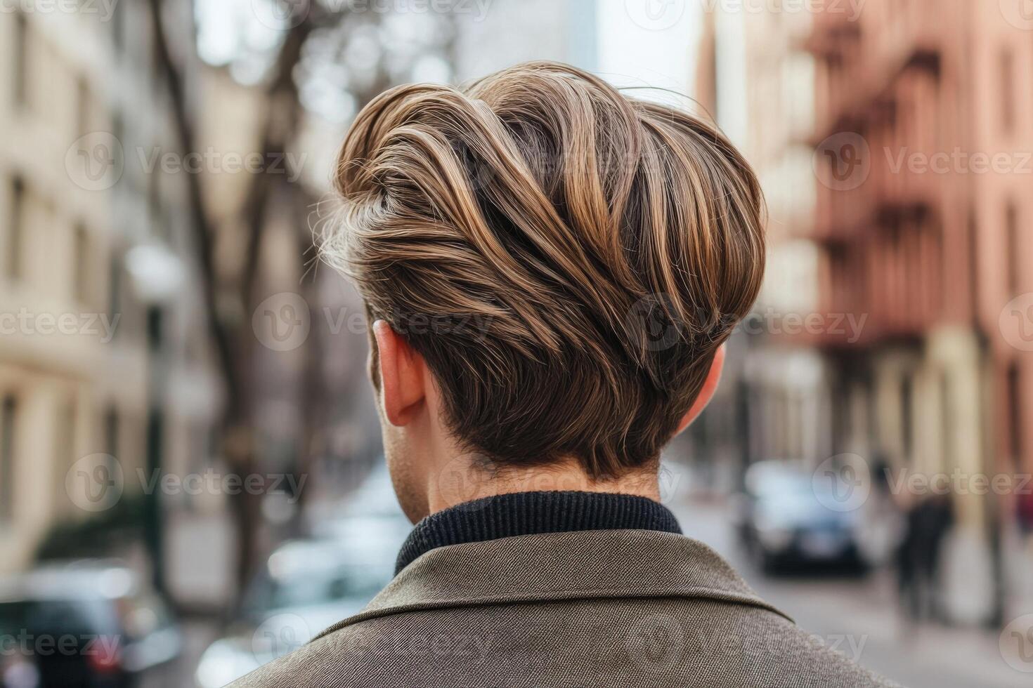Man with stylish hair walking down urban street in the city during the day photo