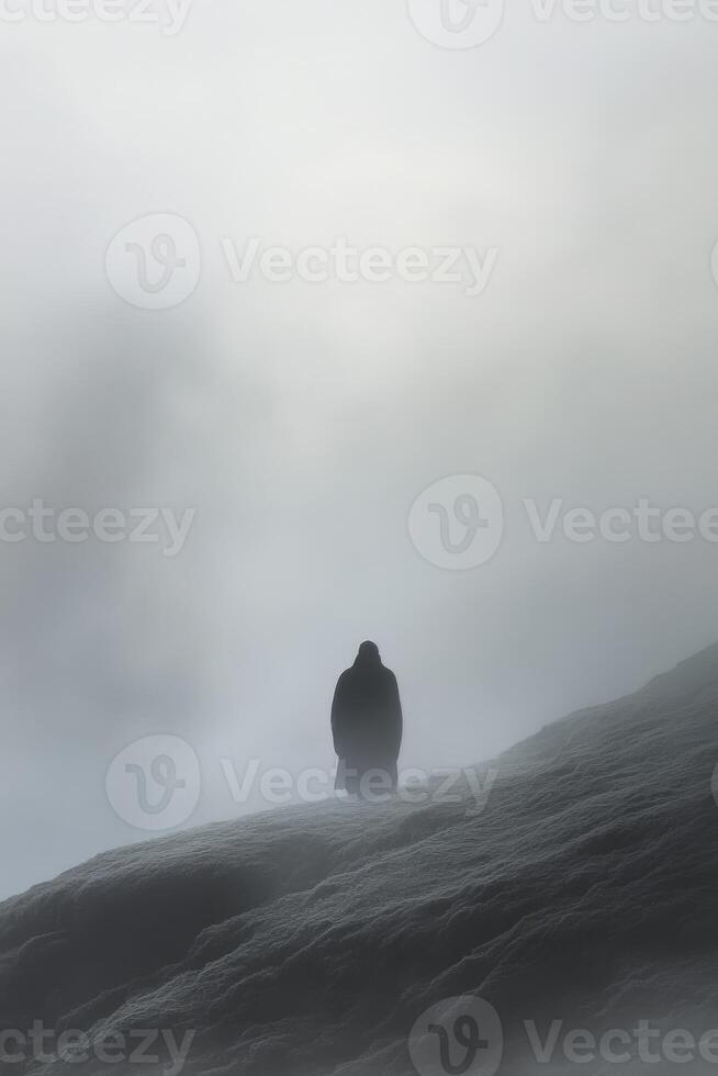 Solitary figure on a foggy mountain at dawn during winter photo