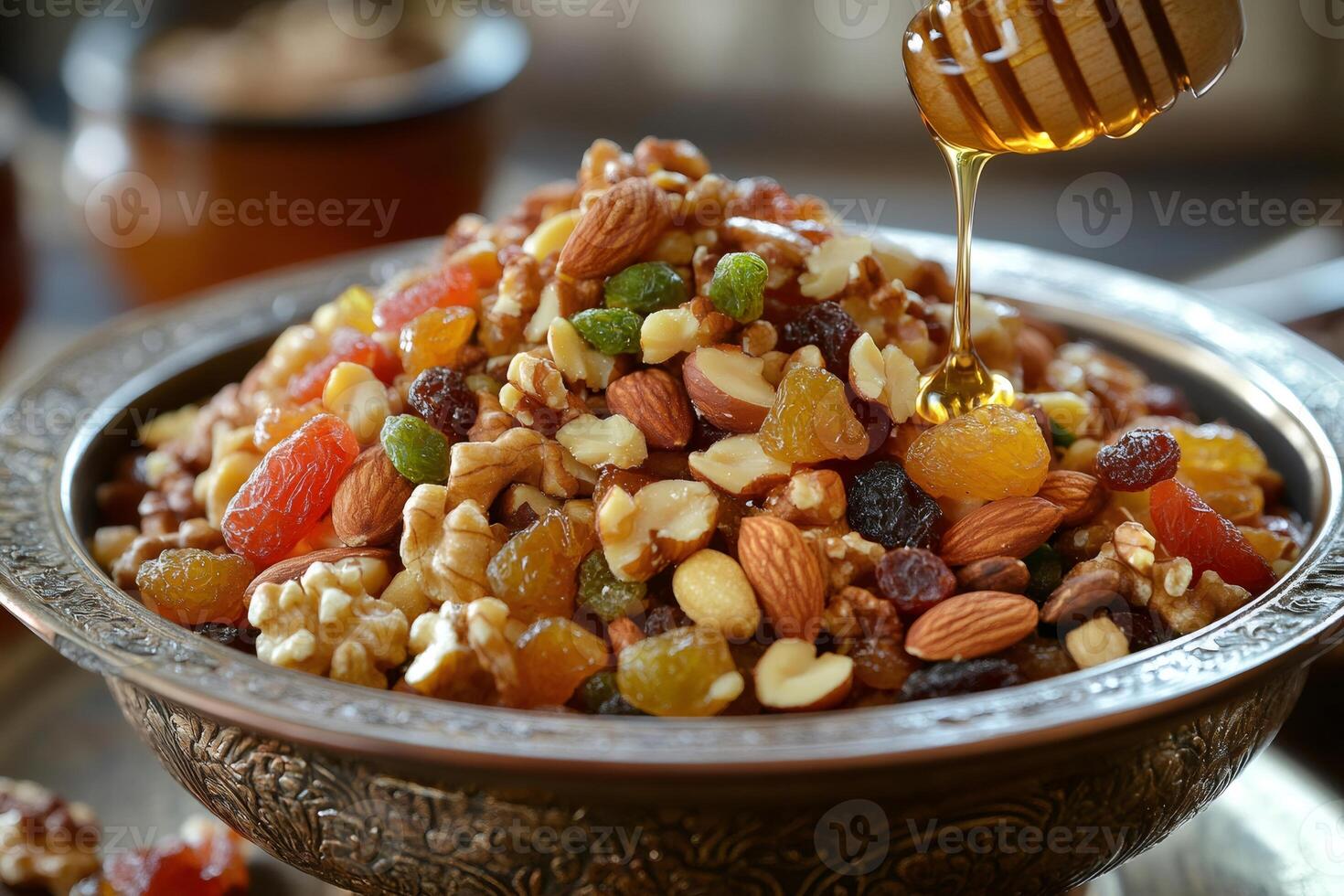 Honey dripping on mixed nuts and dried fruits in an ornate bowl photo