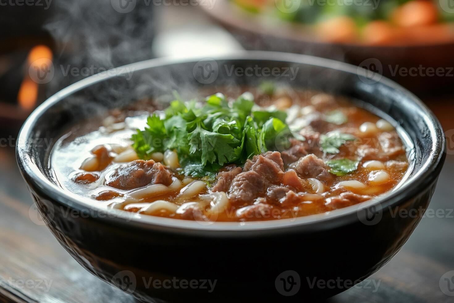 Steaming hot bowl of lagman noodle soup with beef and cilantro photo