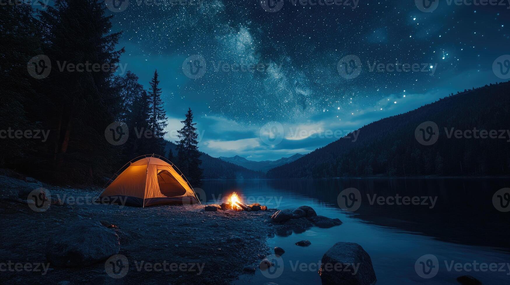 Illuminated tent and campfire by the lake under a starry night sky photo