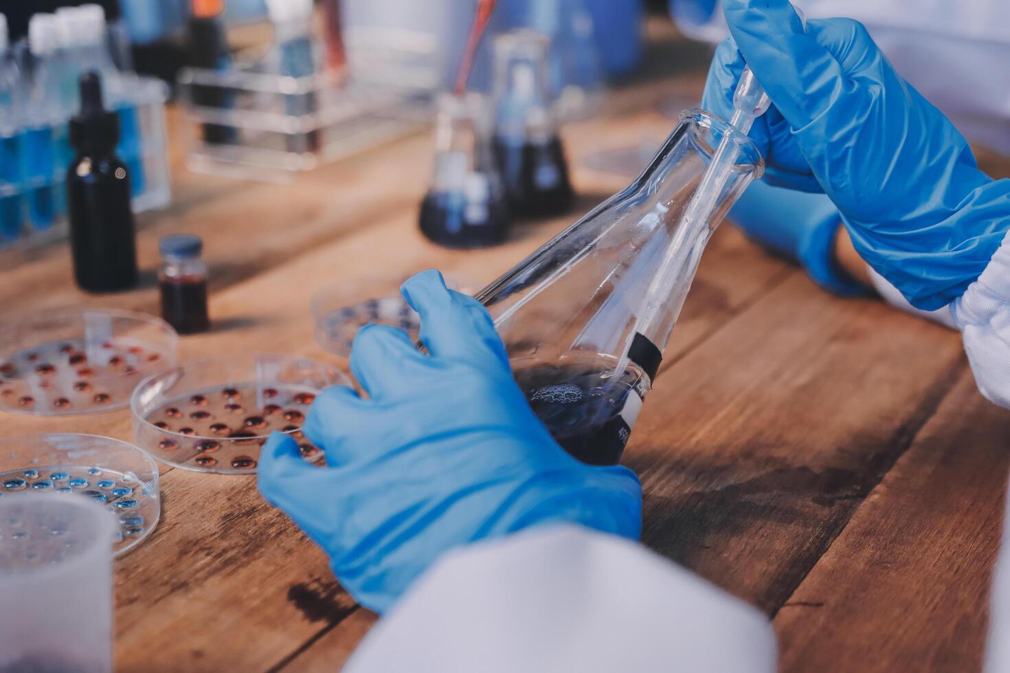 Blood test in the laboratory. Laboratory assistant working with the dispenser. Vacuum tubes with blood. photo
