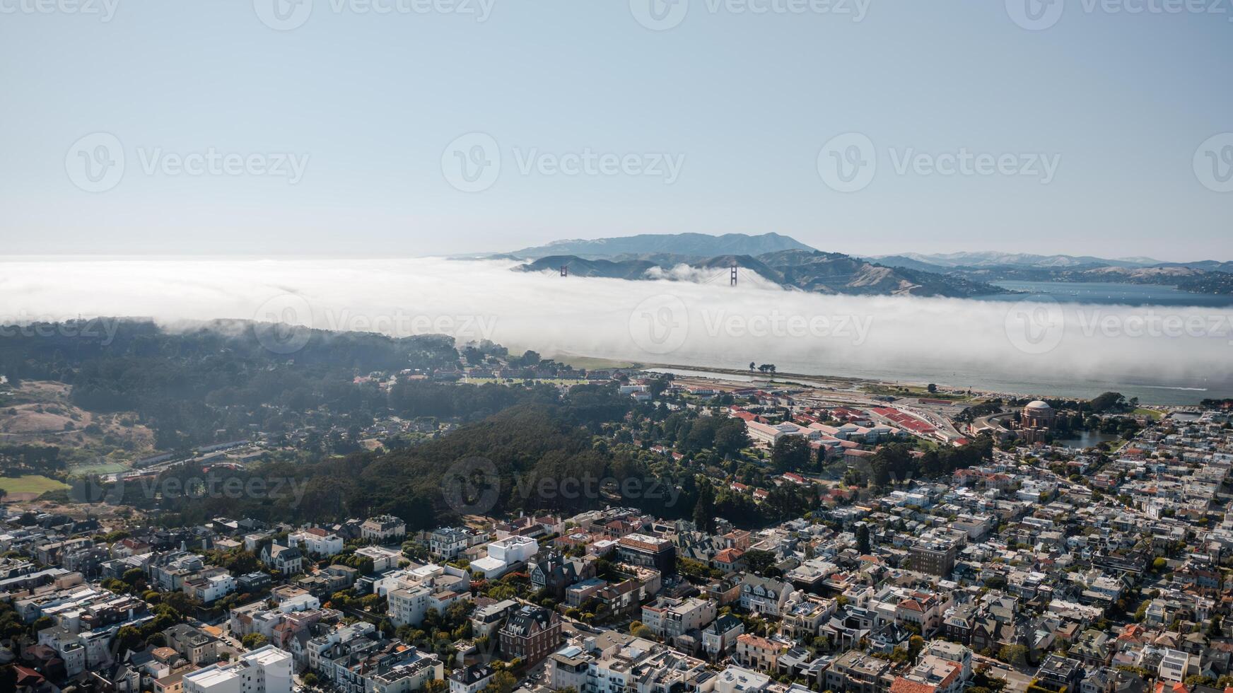 Panoramic aerial view of San Francisco showcasing cityscape and Golden Gate Bridge disappearing in fog photo