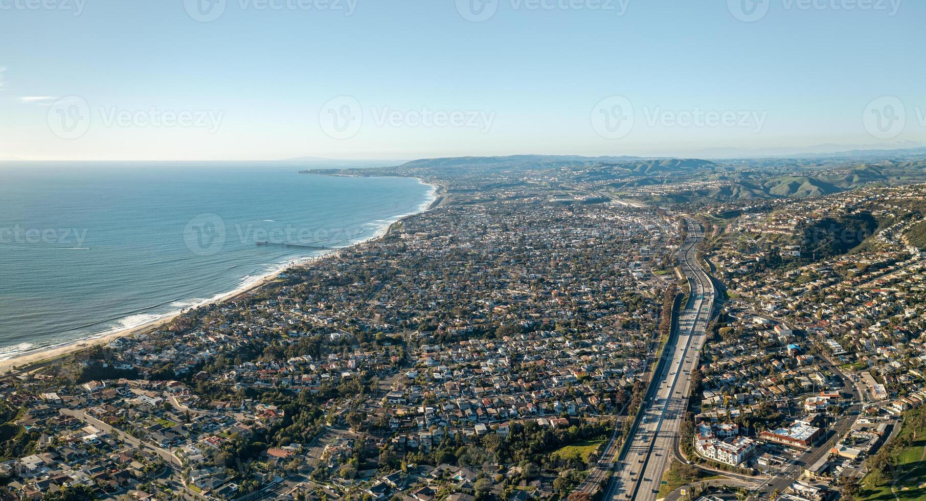 Coastal aerial view of San Clemente, California showcasing beach, homes, pier, I-5 freeway, and ocean horizon photo