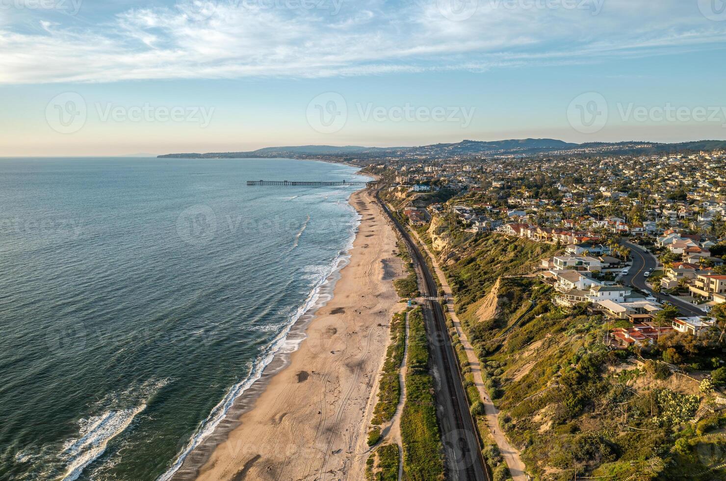 Aerial view of the San Clemente coast showcasing sandy beaches and vibrant ocean waves with pier photo
