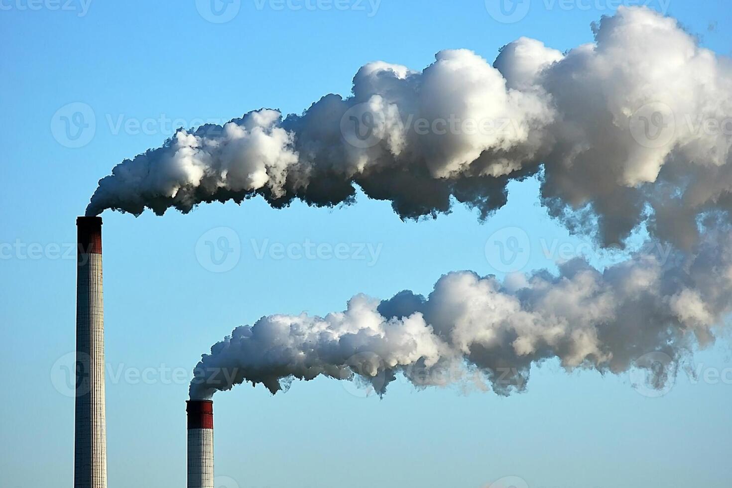Two chimneys with smoke coming out of them photo