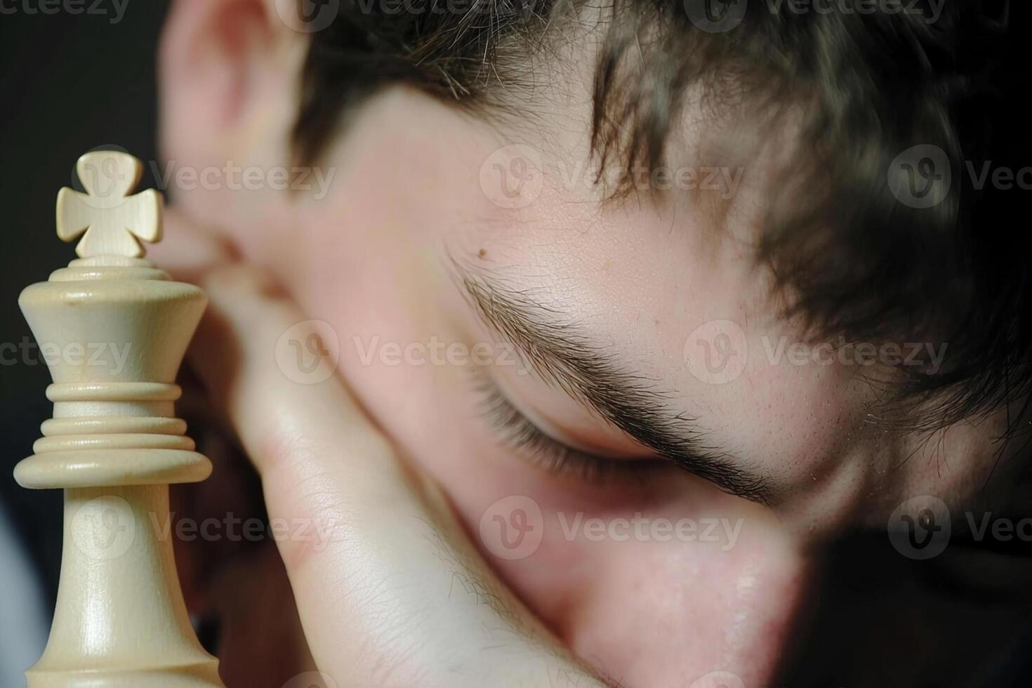 A man is holding his head while playing chess photo