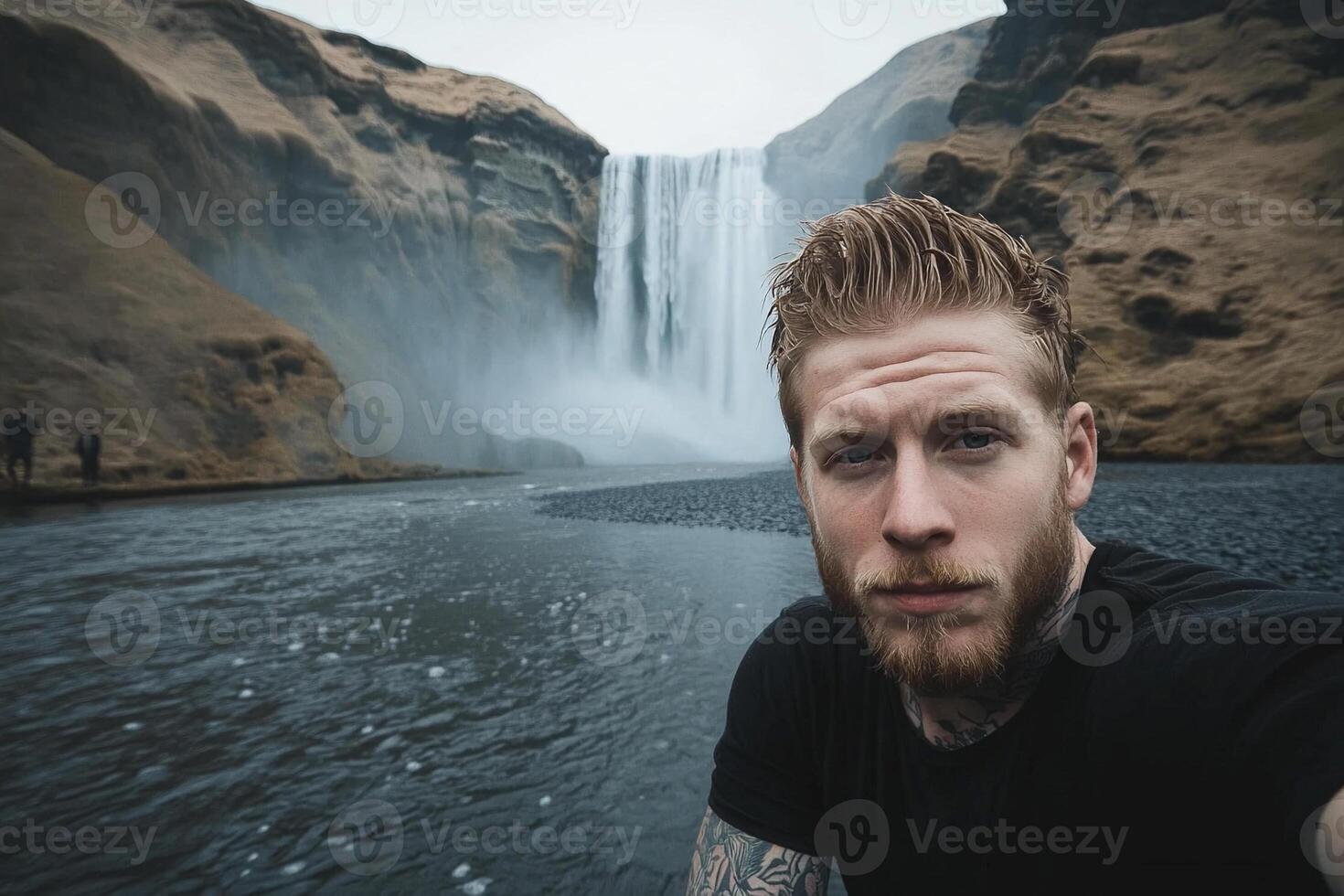 Man taking selfie in front of waterfall photo