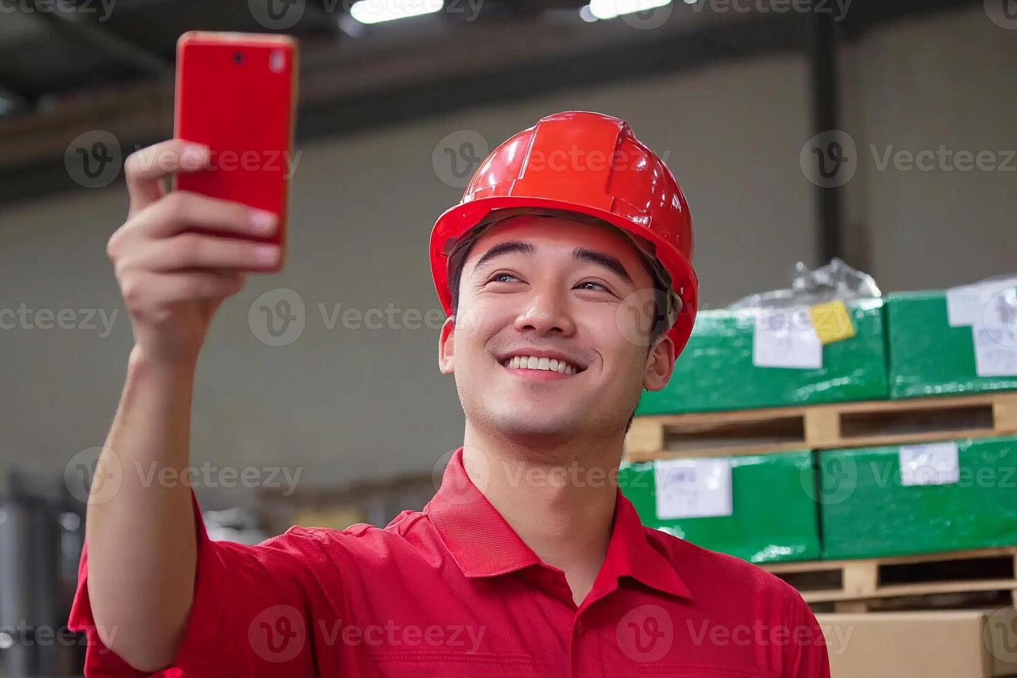A man in a red hard hat taking a selfie photo