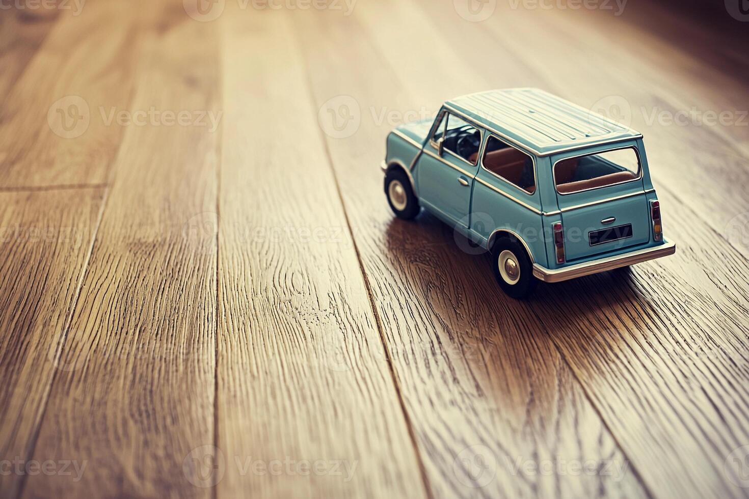A toy car is sitting on a wooden floor photo